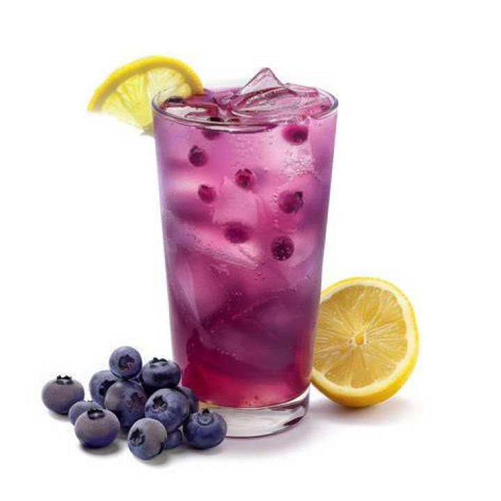 Blueberry lemonade in a glass with a red and white striped straw.