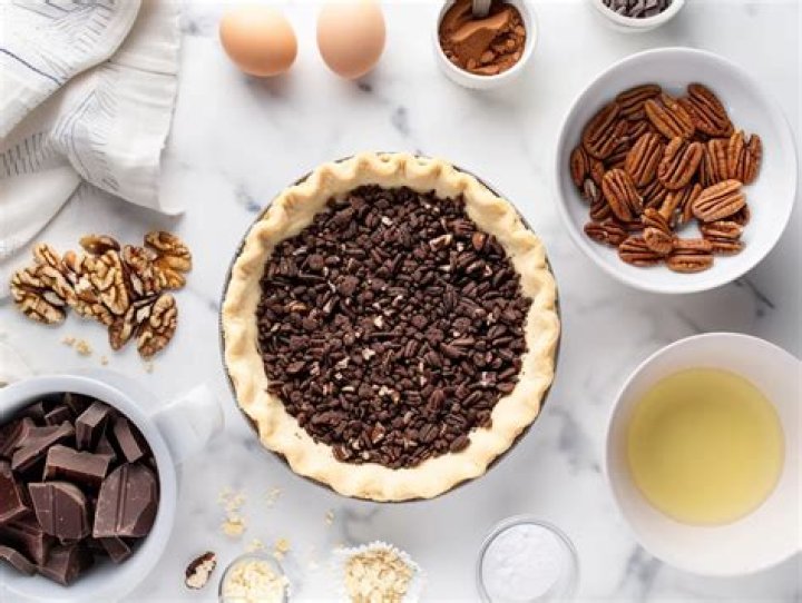 Ingredients for chocolate pecan pie bars: brown sugar, syrup, pecan, chocolate chips, melted butter, egg.